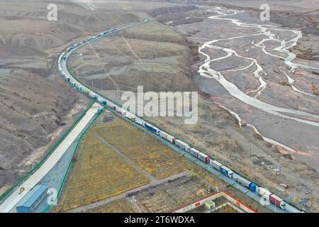 (231112) -- KASHGAR, 12. November 2023 (Xinhua) -- dieses Luftbild vom 7. November 2023 zeigt Lastwagen, die in den Hafen von Irkeshtam in der autonomen Region Xinjiang Uygur im Nordwesten Chinas einfahren. Die Präfektur Kashgar, die einzigartige geografische Vorteile genießt, dient als Tor zur Öffnung und verbindet China mit Zentralasien, Südasien, Westasien und Europa. Durch günstige Maßnahmen, verbesserte Infrastruktur und die Förderung des grenzüberschreitenden Austauschs hat die Präfektur eine rasche Entwicklung erlebt. In den ersten drei Quartalen dieses Jahres der Gesamteinfuhr- und Exportwert in der Präfektur Re Stockfoto