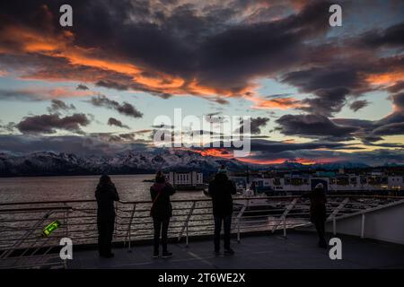 Passagiere, die den Sonnenuntergang vom Deck des Hurtigruten-Schiffes MS Polarlys, Sortland, Lofoten-Inseln, Norwegen einfangen. Stockfoto