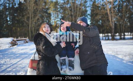 Eine junge Familie isst Mandarinen während eines Picknicks an einem Wintertag. Stockfoto