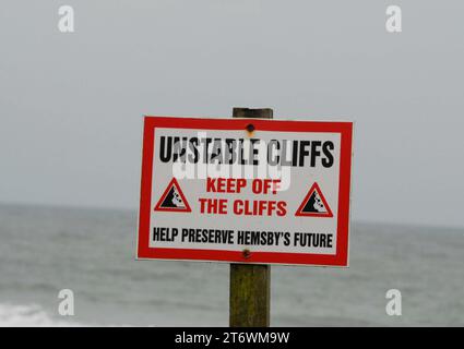 Schild über Sanddünen mit Anzeichen von Erosion, warnt die Strandbesucher vor abbröckelnden Klippen in Southern Marrams. Hemsby Stockfoto