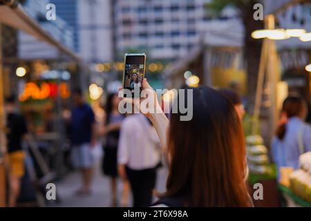 Junge Erwachsene asiatische Frau, die einen Straßenmarkt in Bangkok, Thailand, erkundet. Frau Alleinreisender im Südostasienurlaub. Stockfoto