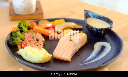 Gourmet-Lachssteak mit gerösteten Kartoffeln und gegrilltem Gemüse Stockfoto