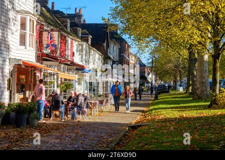 Tenterden High Street, von Bäumen gesäumter breiter Bürgersteig mit Geschäften und Cafés, an einem sonnigen Herbsttag, Kent, Großbritannien Stockfoto