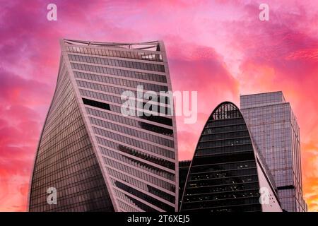 Die Gipfel der modernen Unternehmensgebäude vor dem düsteren roten Sonnenuntergangshimmel. Hochhäuser und Wolkenkratzer Moscow International Business Center. Stockfoto