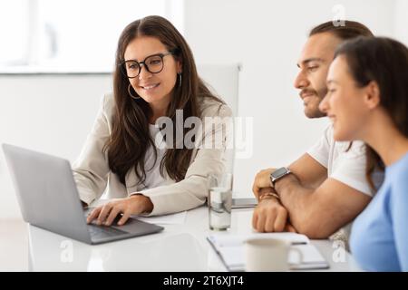 Zufriedener Ehemann und Ehefrau im Dialog mit reifem Gutsberater Stockfoto