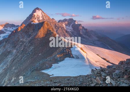 Gran Zebrù Berg leuchtet orange während des wunderschönen alpinen Sonnenaufgangs. Sonnenaufgang auf dem Gipfel mit Blick auf Gipfel und Schneefelder. Stockfoto