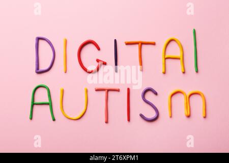 Phrase Digital Autismus aus buntem Plastilin auf rosa Hintergrund, flach. Suchtverhalten Stockfoto