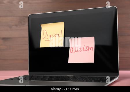 Haftnotizen mit dem Satz Digital Autism am Laptop auf dem Tisch, Nahaufnahme. Suchtverhalten Stockfoto