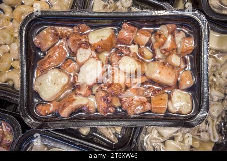 Oktopustentakel in Stücken in vakuumversiegelten Tabletts zum Sous-Vide-Kochen zum Verkauf in Kühltheken in Supermärkten Stockfoto