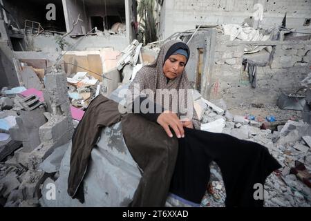 Rafah, Gaza. November 2023. Amal al-Robayaa 44, verbreitete die Kleidung in den Ruinen des Familienhauses, das bei einem israelischen Streik in Rafah im südlichen Gazastreifen am Sonntag, den 7. November 2023 zerstört wurde. Robayaa sagt, dass der Wohnblock, in dem er lebte, am 7. Oktober, dem ersten Tag des Krieges in Gaza, durch einen israelischen Bombardement zerstört wurde. Amal Rabayaa, Ehemann von Imad, versickert nun mit anderen Familienmitgliedern in einer UN-Schule in Rafah, kehrt aber am Morgen in ihr Zuhause zurück und stellt sich dem täglichen Kampf um Nahrung und Wasser. Foto: Ismael Mohamad/UPI Credit: UPI/Alamy Live News Stockfoto