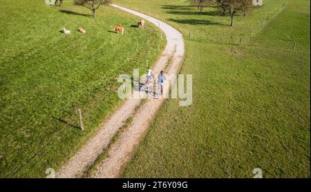 Freizeitradtour mit zwei Radfahrern mit einem fantastischen Blick auf Bergpanorama, Herbstwälder und grüne Wiesen, Luftaufnahme. Radtourismus Stockfoto