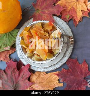 Kandierter und getrockneter Kürbis. Nahaufnahme von kandierten hausgemachten Kürbisfrüchten von einer natürlichen Farm, bestreut mit Puderzucker. Stockfoto