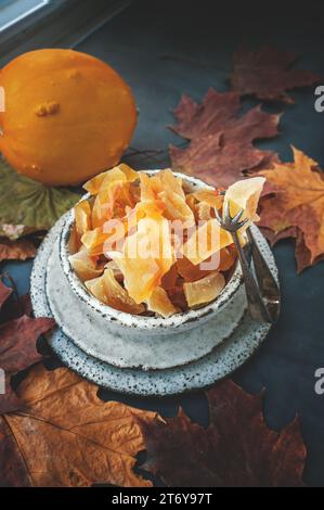 Kandierter und getrockneter Kürbis. Nahaufnahme von kandierten hausgemachten Kürbisfrüchten von einer natürlichen Farm, bestreut mit Puderzucker. Stockfoto