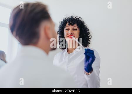 Ein erfahrener Arzt kontrolliert den Blutdruck und den Blutzucker eines Patienten, führt eine Höruntersuchung durch und betreut eine Indoor-Klinik. Stockfoto