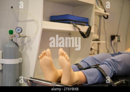 Patient auf einer Liege in einer Trainingspuppe im Krankenwagen. Medizinische Geräte. Stockfoto