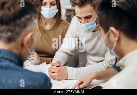 Menschen, die medizinische Masken tragen, arbeiten Stockfoto