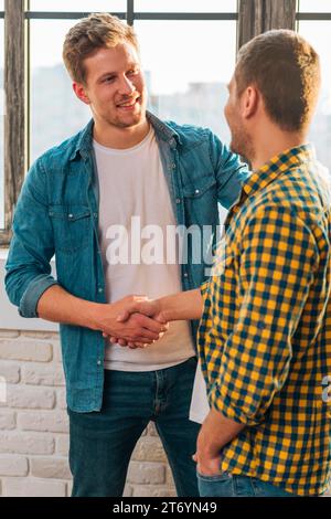 Ein lächelndes Portrait junger Mann schüttelt die Hand Stockfoto