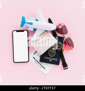 Pass Karte Tickets Spielzeug Flugzeug Handgelenk Uhr Handy Sonnenbrille rosa Hintergrund Stockfoto