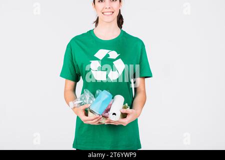 Lächelnde Frau, die Plastikflaschen in Blechdosen hält Stockfoto