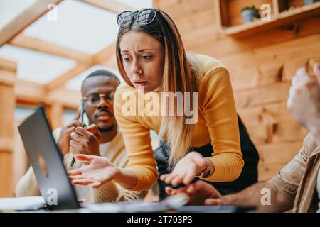 Multikulturelles Business-Team diskutiert Strategien für Startup-Finanzierung und Growth Hacking in Urban Cafe Stockfoto