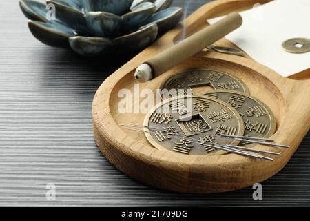 Akupunkturnadeln, Moxa-Stick und antike chinesische Münzen auf Holztisch, Nahaufnahme Stockfoto