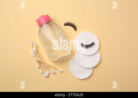 Flache Lay-Komposition mit Make-up-Entferner und falschen Wimpern auf gelbem Hintergrund Stockfoto