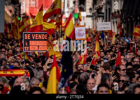 Demonstranten der Volkspartei tragen spanische Fahnen und Plakate, die ihre Meinung während einer Demonstration gegen die Amnestie von Pedro Sanchez zum Ausdruck bringen. Die von der Volkspartei organisierte Demonstration gegen den Pakt zwischen der PSOE (spanischer Sozialistischer Arbeiterpartei) und Junts (katalanischer politischer Partei), der am 9. November in Brüssel unterzeichnet wurde, um den amtierenden Premierminister und sozialistischen Kandidaten für die Wiederwahl, Pedro Sanchez, zu investieren. Der Pakt mit Junts enthält ein mögliches Amnestiegesetz für diejenigen, die wegen des „Verfahrens“ verurteilt wurden. (Foto: Guillermo Gutierrez Carrascal / SOPA Images/SIPA USA) Stockfoto