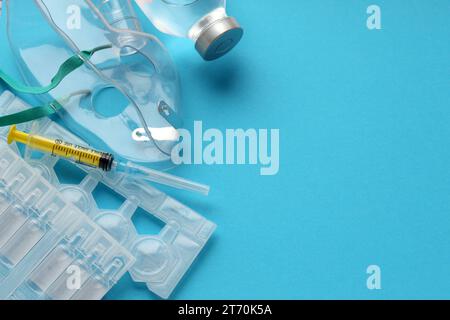 Coronavirus-Behandlungskonzept. Ein medizinischer Gesichtsmasken-Vernebler für die Behandlung der Atemwege und Ampullen flach auf blauem Hintergrund gelegt. Kopierbereich Stockfoto