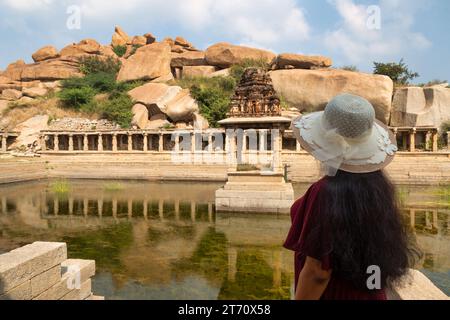 Weibliche Touristen genießen den Blick auf Pushkarani, ein altes Wasserreservoir in Hampi Karnataka, Indien. Stockfoto