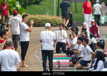 JAKARTA, INDONESIEN - 11. NOVEMBER 2023: Anjasmara Prasetya lehrt und praktiziert Yoga mit einer Gruppe nicht identifizierter Menschen im Tebet Eco Park, Jakarta Stockfoto