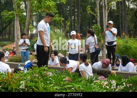 JAKARTA, INDONESIEN - 11. NOVEMBER 2023: Anjasmara Prasetya lehrt und praktiziert Yoga mit einer Gruppe nicht identifizierter Menschen im Tebet Eco Park, Jakarta Stockfoto