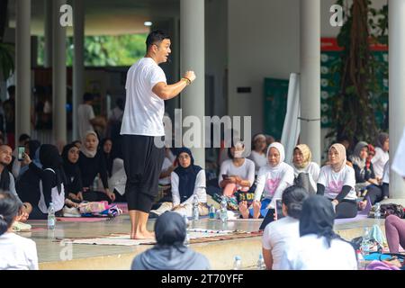 JAKARTA, INDONESIEN - 11. NOVEMBER 2023: Anjasmara Prasetya lehrt und praktiziert Yoga mit einer Gruppe nicht identifizierter Menschen im Tebet Eco Park, Jakarta Stockfoto