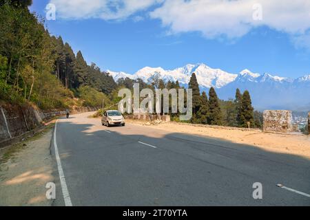 Malerische Bergstraße in der Nähe von Lava Kalimpong, Indien, mit der Kachenjunga Himalaya Bergkette im Hintergrund Stockfoto