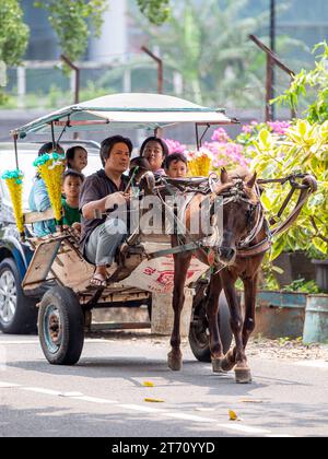 Jakarta, Indonesien - 11. November 2023: Nicht identifizierte Menschen, die mit einer Pferdekutsche auf den Straßen von Jakarta fahren. Stockfoto