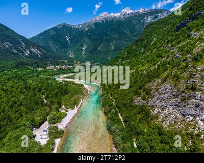 Soca-Tal, Slowenien - Luftaufnahme des smaragdgrünen alpinen Flusses Soca an einem hellen, sonnigen Sommertag mit julanischen Alpen, blauem Himmel und grünem Laub Stockfoto