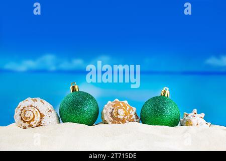 Glänzende grüne Kugeln mit Muscheln auf Sand am Strand. Weihnachten, Neujahr. Copy spaceShiny grüne Kugeln mit Muscheln auf Sand des Strandes. Weihnachten, New Ye Stockfoto