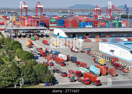 NANJING, CHINA - 13. NOVEMBER 2023 - Güterwagen fahren in Nanjing, Jiangsu, in geordneter Weise in das Containerterminal des Hafens Nanjing ein und verlassen es Stockfoto