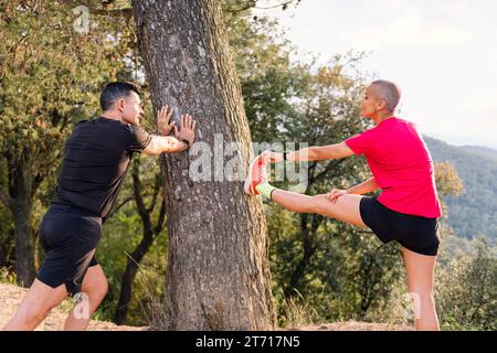 Ein Paar, das sich für das Training in der Natur ausdehnt Stockfoto