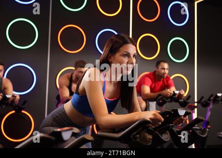 Gruppe von Personen, die im Fitnessklub auf Fahrrädern trainieren Stockfoto