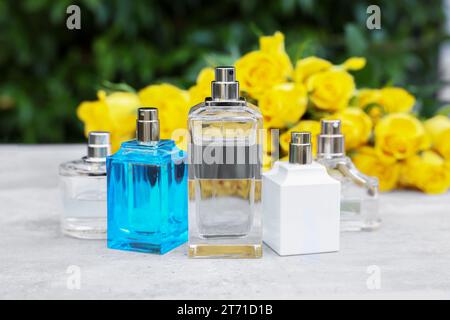 Parfums und schöner Strauß gelber Rosen auf Lichttisch im Freien, selektiver Fokus Stockfoto