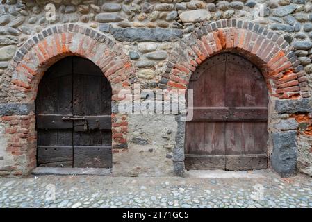 Italien, Rezept von Candelo. Panorama des mittelalterlichen Dorfes. Geschichte und Kultur Italiens und Europas. Isolierte Holztür im Vordergrund. Stockfoto