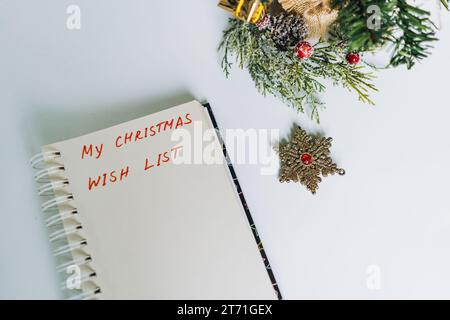 Öffnen Sie den Notizblock mit dem Text für die weihnachtswünsche. Geschmückter weihnachtsbaum auf Hintergrund Stockfoto