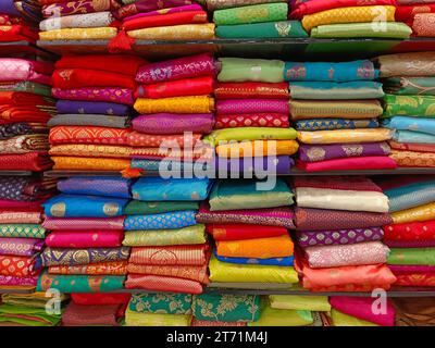 Diese exquisiten, teuren Saris sind in einem Textilgeschäft in verschiedenen Regalen angeordnet und berühmt für ihren Gold- und Silberzari und Brokat. I Stockfoto