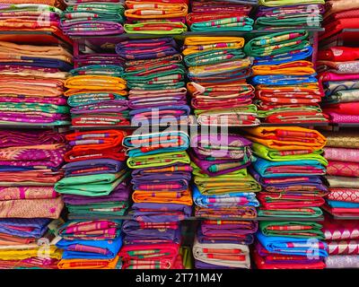 Diese exquisiten, teuren Saris sind in einem Textilgeschäft in verschiedenen Regalen angeordnet und berühmt für ihren Gold- und Silberzari und Brokat. I Stockfoto