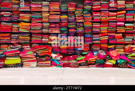 Diese exquisiten, teuren Saris sind in einem Textilgeschäft in verschiedenen Regalen angeordnet und berühmt für ihren Gold- und Silberzari und Brokat. I Stockfoto