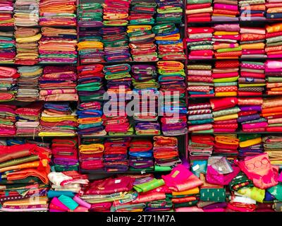 Diese exquisiten, teuren Saris sind in einem Textilgeschäft in verschiedenen Regalen angeordnet und berühmt für ihren Gold- und Silberzari und Brokat. I Stockfoto