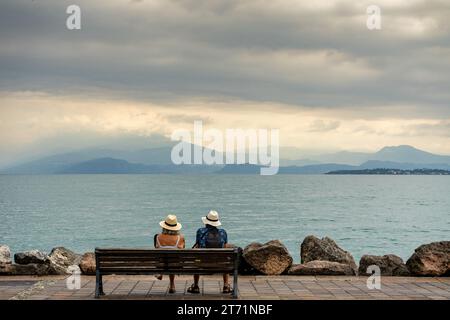 Ein altes Paar sitzt auf einer Bank am Gardasee Stockfoto