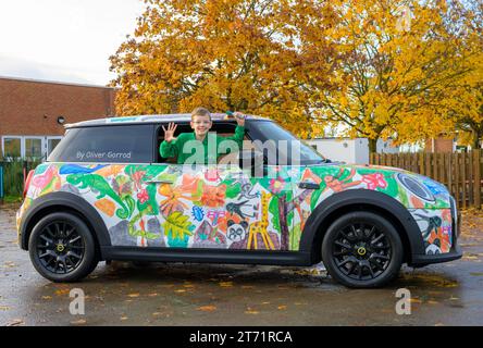 Der Gewinner des Wettbewerbs, Oliver Gorrod, 9 Jahre alt von Didcot Pose mit einem MINI Electric, der seine „MINI-Köpfe“ zeigt... Mit Crayolas erfolgreichem Design, wie es an seiner Schule vorgestellt wird, Sutton Courtenay C von der E Primary School in Abingdon, Oxfordshire. Ausgabedatum: Montag, 13. November 2023. Stockfoto