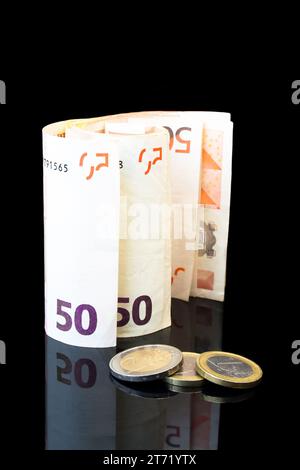 Detail der Geldrolle mit Euro-Münzen auf schwarzem Hintergrund; Detail der Geldrolle mit Euro-Münzen auf schwarzem Hintergrund Stockfoto