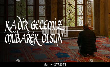 Ein Mann betet in der Moschee in einer spirituellen Atmosphäre. Kadir Gecesi Mubarek Olsun. Frohe den 27. Tag des Ramadan oder laylat al-qadr Text im Bild. Stockfoto